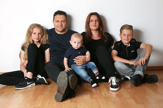 Familienfoto sitzend an der Wand