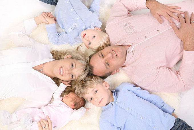 Familienfoto mit drei Kinder liegend